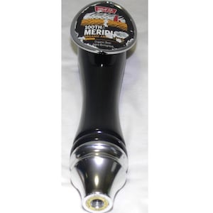May include: Black beer tap handle with a silver top. The top has a circular label with the text "100th MERIDIAN ORGANIC AMBER LAGER" and the words "Organic Beer Biere Biologique".