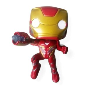 May include: A red and gold Iron Man figurine in a dynamic pose, with a raised arm and a weaponized hand. The figure has a gold helmet with white eye cutouts and a red body with silver accents. A collectible item.