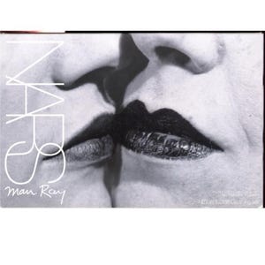 May include: Monochrome box featuring a close-up of two faces with dark lipstick. The NARS logo is in white, with "Man Ray" written below. The image is a black and white photograph.