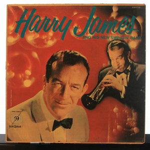 May include: A vintage vinyl record album cover featuring Harry James and his New Swingin' Band. The cover art features a red background with a photo of Harry James playing a trumpet and a photo of him in a tuxedo. The album cover has a MGM logo and the text "High Fidelity".
