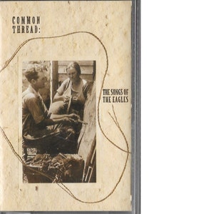 May include: A vintage-style album cover featuring a sepia-toned photograph of two people working on a loom. The album title is "COMMON THREAD: THE SONGS OF THE EAGLES".