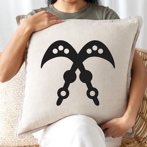 May include: A white throw pillow with a black Adinkra symbol, the Sankofa, which represents the importance of learning from the past.
