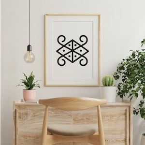 May include: A black and white geometric design print in a gold frame hanging on a white wall. The print is of a stylized symbol with four curved lines and a central square with four dots.