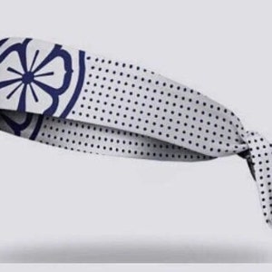 Puede incluir: Diadema blanca con un diseño de flor azul marino y lunares blancos.