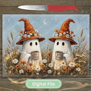 May include: A rectangular glass cutting board featuring two white ghosts wearing orange witch hats adorned with daisies, each holding a mug labeled Boo Brew. The scene is set in a field of wildflowers under a crescent moon, with a red-handled knife above.
