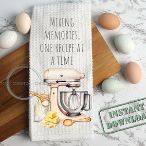 Op de afbeelding: Witte keukendoek met een roze standmixer, een zak bloem, boter en een houten lepel. De tekst op de handdoek luidt "Mixing Memories, One Recipe at a Time". Een groene stempel met de tekst "Direct downloaden" bevindt zich op de witte marmeren achtergrond.