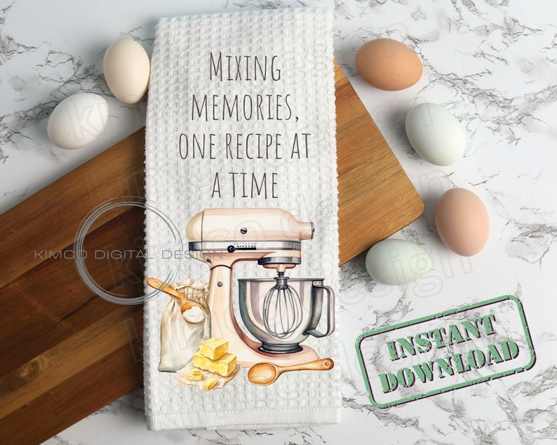 Op de afbeelding: Witte keukendoek met een roze standmixer, een zak bloem, boter en een houten lepel. De tekst op de handdoek luidt "Mixing Memories, One Recipe at a Time". Een groene stempel met de tekst "Direct downloaden" bevindt zich op de witte marmeren achtergrond.