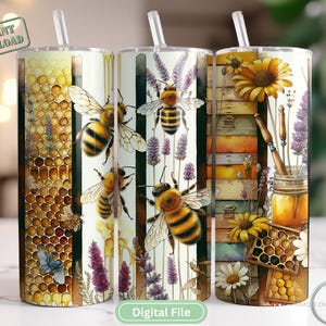 Puede incluir: Tres vasos de acero inoxidable de 20 onzas con diferentes diseños. El primer vaso presenta un patrón de panal con abejas y flores. El segundo vaso tiene un fondo a rayas blanco y negro con abejas y flores. El tercer vaso tiene un fondo de madera con una colmena, flores y un tarro de miel.