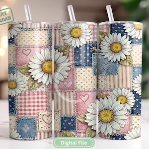 May include: Three stainless steel tumblers with daisy and patchwork designs. The tumblers feature white daisies with yellow centers, set against a backdrop of pink, blue, and cream patchwork patterns. Each tumbler has a clear straw.