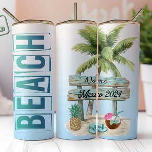 May include: A stainless steel travel mug with a beach theme. The mug features the word "BEACH" in large teal letters, and a tropical scene with a palm tree, sign that says "Name Mexico 2024", pineapple, and a coconut drink.