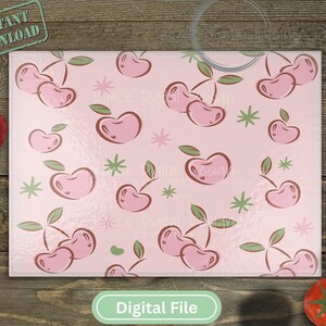 May include: Pink cutting board with a repeating pattern of cherries. The cherries are pink and have green stems and leaves. The background is a light pink color.