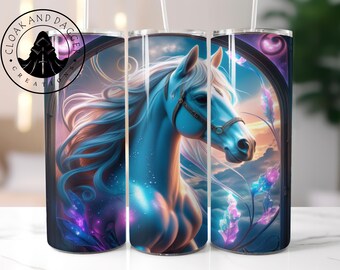 May include: A tumbler featuring a blue horse with a flowing mane and a bridle. The horse is set against a backdrop of a sunset and floral accents. The tumbler has the text "CLOAK AND DAGGER CREATIONS" around a circular logo.