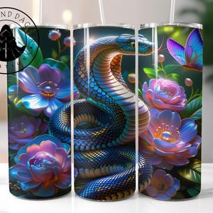 May include: A set of three stainless steel tumblers featuring a vibrant design of a blue and gold snake coiled among colorful flowers and a butterfly. The tumblers have a capacity of 20 ounces.