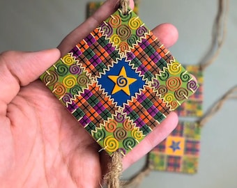 Colcha de retalhos com estrela amarela no centro, espirais e padrão xadrez (enfeite de parede)