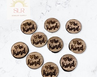 Puede incluir: Diez discos redondos de madera con la frase "be kind" y un símbolo de corazón grabado en cada disco.
