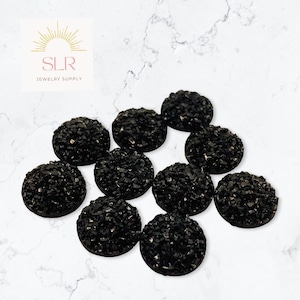 Peut inclure: Dix cabochons ronds noirs avec une finition scintillante et pailletée. Les cabochons mesurent environ 2,5 cm de diamètre.