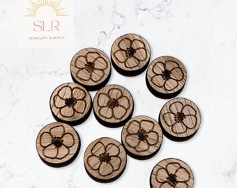 Puede incluir: Diez discos redondos de madera con un diseño floral grabado con láser. Los discos son de color marrón claro y tienen una veta de madera natural.