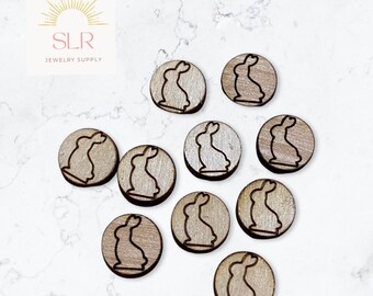 Può includere: Dodici ornamenti rotondi in legno con un design a silhouette di coniglio. Gli ornamenti sono di colore marrone chiaro con venature del legno naturali.