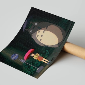 May include: Poster print of a scene from the animated film, My Neighbour Totoro. The artwork shows Totoro, a large forest spirit, and a young girl with an umbrella at a bus stop in the rain. The poster is rolled up.