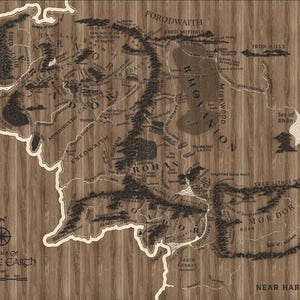 Può includere: Una mappa dettagliata della Terra di Mezzo, con regioni geografiche e nomi di luoghi tratti dal Signore degli Anelli. La mappa è stampata su uno sfondo a venature di legno. La rosa dei venti e la scala sono visibili in basso a sinistra.