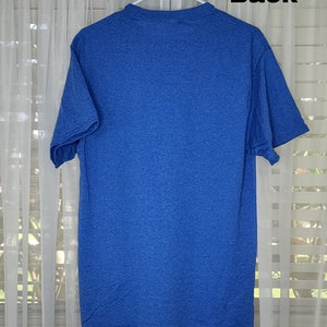 Peut inclure: Un t-shirt bleu royal chin&eacute; &agrave; manches courtes. L'arri&egrave;re du t-shirt est montr&eacute;.
