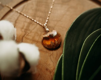 Round pendant in eucalyptus wood and orange resin mountainous reliefs in wood essence