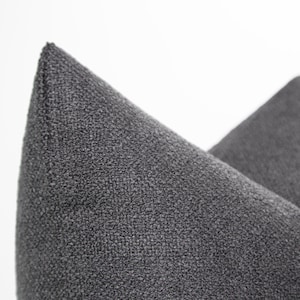May include: Two gray throw pillows with a textured fabric surface.
