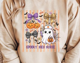 May include: A sand-colored crewneck sweatshirt featuring a graphic print with the text "SPOOKY NICU NURSE". The design includes a ghost wearing a nurse cap, pumpkins, bows, a stethoscope, baby footprints, a baby bottle, and a pacifier.