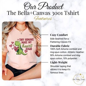 May include: Pink Bella+Canvas 3001 T-shirt with a green dinosaur graphic and the text "Tiny Humans Make My Heart Rawr". The shirt features a side-seamed classic fit, soft airlume combed and ring-spun cotton, and shoulder taping.