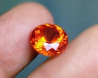 Anillo de joyería con piedra preciosa de zafiro naranja natural, talla facetada y forma redonda. Joyería personalizada con piedra suelta.