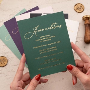 Może przedstawiać: Zielona karta z pozłacanymi napisami, na której wymieniono zakwaterowanie na ślub. Karta zawiera tekst: "Zakwaterowanie", "Hotel Noma Trademark Collection by Wyndham", "1 Radisson Plaza Los Angeles, CA 10801", "Holiday Inn Express & Suites Los Angeles", "405 Chavez Street Los Angeles, CA 90012".