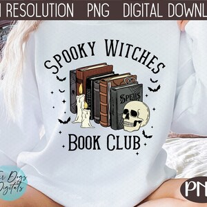 Puede incluir: Una sudadera blanca con el texto "Spooky Witches Book Club" en negro. El texto est&aacute; rodeado por una pila de libros con t&iacute;tulos como "Potions" y "Spells", una calavera y murci&eacute;lagos.