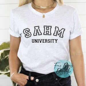 K&ouml;nnte beinhalten: Wei&szlig;es T-Shirt mit schwarzem Text, der "SAHM UNIVERSITY" lautet.