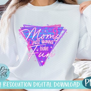 May include: White sweatshirt with a pink and blue graphic design that says "Mom's Just Wanna Have Fun" in a retro 80s style font.