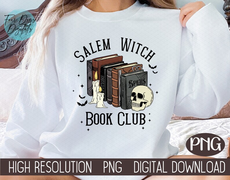 K&ouml;nnte beinhalten: Wei&szlig;es Sweatshirt mit einem grafischen Design aus einem Stapel B&uuml;cher mit einem Sch&auml;del und Kerzen. Der Text "Salem Witch Book Club" ist auf dem Sweatshirt aufgedruckt.