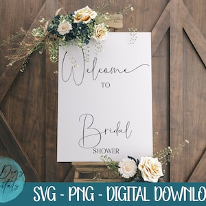 May include: White sign with black calligraphy that reads "Welcome to Bridal Shower" on a wooden background with flowers.