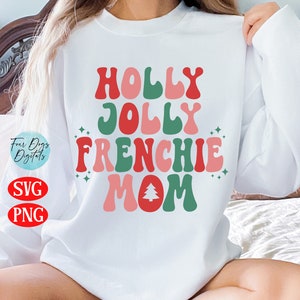 Puede incluir: Sudadera blanca con el texto "HOLLY JOLLY FRENCHIE MOM" en fuente retro roja, verde y rosa. Incluye un gr&aacute;fico de &aacute;rbol de Navidad. La sudadera tambi&eacute;n tiene el texto "SVG" y "PNG".