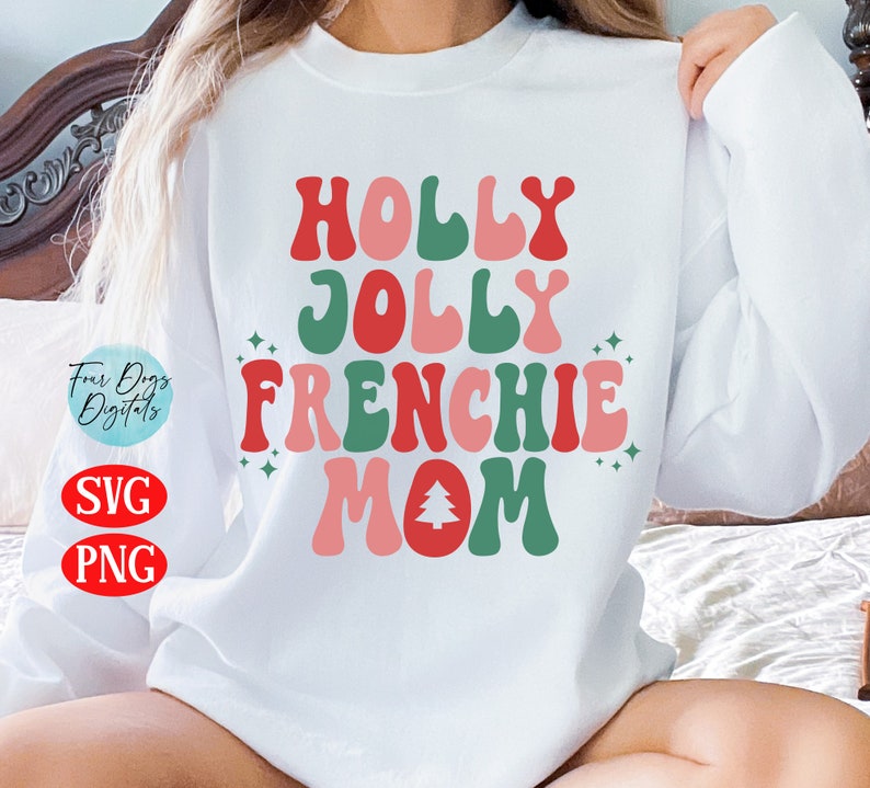 Puede incluir: Sudadera blanca con el texto "HOLLY JOLLY FRENCHIE MOM" en fuente retro roja, verde y rosa. Incluye un gr&aacute;fico de &aacute;rbol de Navidad. La sudadera tambi&eacute;n tiene el texto "SVG" y "PNG".