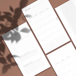 Op de afbeelding: Vier printbare plannerpagina's met het woord "MAAND" bovenaan elke pagina. De pagina's bevatten secties voor maandelijkse intenties, belangrijke data, een kalenderrooster en een gewoontetracker.
