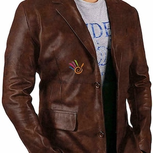 May include: A brown leather blazer with a single button closure. The blazer has a pocket on the left side and a small logo on the right side that says "HANDMADE".