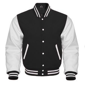 May include: A black and white varsity jacket with white leather sleeves and a black wool body. The jacket has a ribbed collar, cuffs, and waistband with white stripes. It features a button closure and two front pockets.