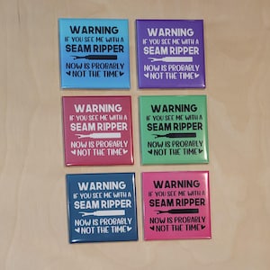 May include: A collection of six rectangular magnets in various colors, each featuring the text "WARNING IF YOU SEE ME WITH A SEAM RIPPER NOW IS PROBABLY NOT THE TIME" and a seam ripper graphic.