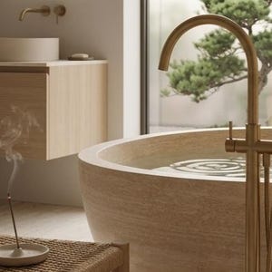 May include: A tranquil bathroom with a stone-effect bathtub and gold-coloured taps. A wooden vanity unit with a circular sink is visible. Incense burns, creating a relaxing atmosphere. The scene evokes a spa-like feel.