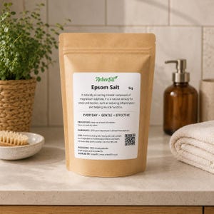 K&ouml;nnte beinhalten: Ein brauner Kraftpapierbeutel mit 1kg Bittersalz. Das wei&szlig;e Etikett zeigt das Arborfill-Logo, die Produktbeschreibung, Inhaltsstoffe und einen QR-Code. Der Text lautet: Epsom Salt, 1kg, A naturally occurring mineral compound of magnesium sulphate, it is a natural remedy for stress and tension, such as reducing inflammation and helping muscle function. EVERYDAY, GENTLE, EFFECTIVE.