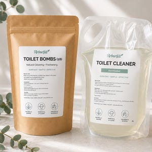 May include: A brown paper pouch labelled Arbortill Toilet Bombs (18) and a clear plastic spout pouch labelled Arbortill Toilet Cleaner Eucalyptus. Both feature white labels with black text, ingredient lists, and three circular icons at the bottom.