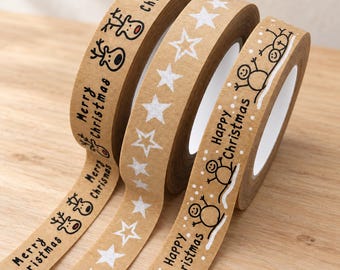 Könnte beinhalten: Drei Rollen braunes Kraftpapier-Klebeband mit weihnachtlichen Motiven. Eine Rolle zeigt schwarze Rentiere und den Text Merry Christmas. Die zweite Rolle hat weiße Sterne. Die dritte Rolle zeigt Schneemänner und den Text Happy Christmas.