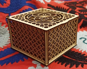 Op de afbeelding: Een houten doos met ingewikkelde geometrische patronen die in de zijkanten zijn gesneden. De doos is gemaakt van lichtbruin hout en heeft een vierkante vorm.