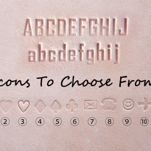 May include: Close-up of a light brown leather surface with embossed uppercase and lowercase letters, and various icons. The text "Icons To Choose From" is written below the letters. The icons include a star, heart, spade, and more.