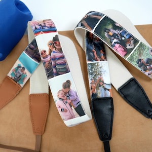 May include: Two personalised camera straps with custom photo prints. One strap has brown leather ends and the other has black leather ends. A blue drawstring bag is in the background. The straps have a cream-coloured fabric base.