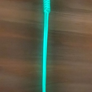 May include: A bright green glow-in-the-dark paracord lanyard with a black clip.